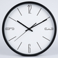 Horloge murale minimaliste noire et blanche, chiffres fins aux positions 12, 3, 6 et 9 et index à traits.