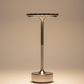 Lampe de chevet design italien rechargeable argentée allumée sur fond beige chaud, éclairage LED blanc chaud sans fil tactile en aluminium brossé, ambiance moderne et élégante