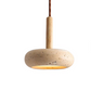Gros plan sur la lampe de chevet suspendue en travertin, détail de la base minérale et du câble pour un style Wabi-Sabi premium